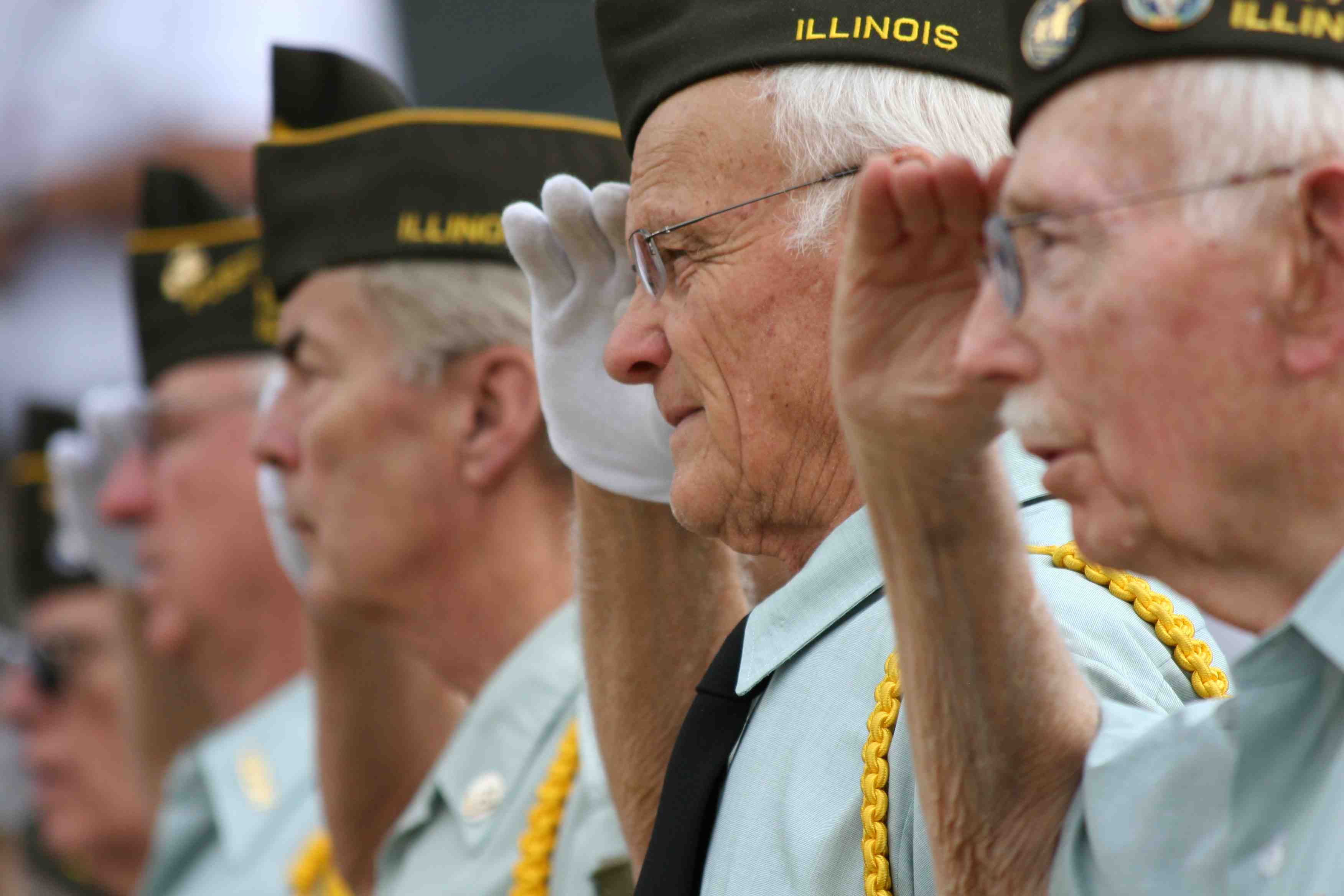 Senior veterans in a line saluting.